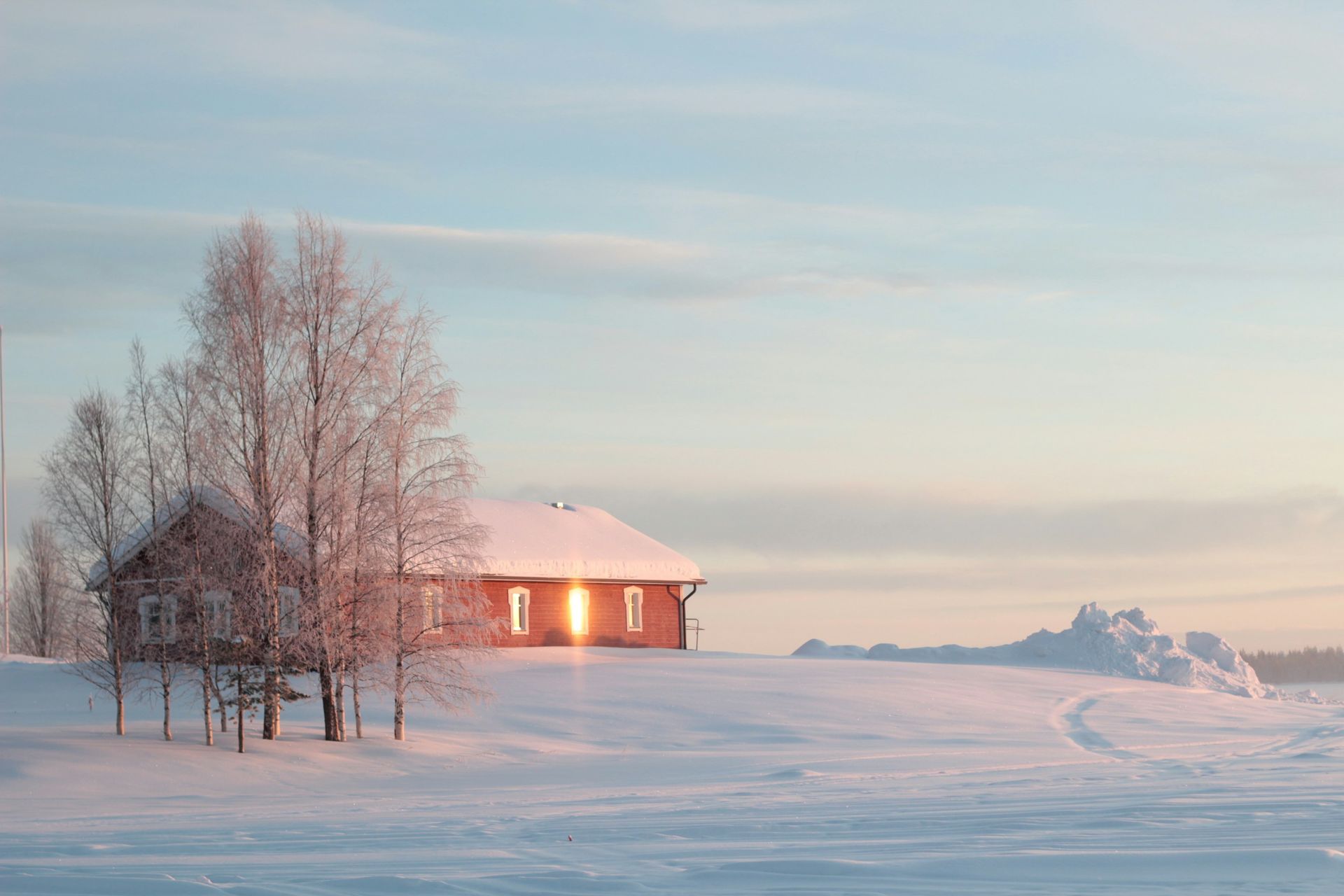 Red farmhouse in snow at dawn